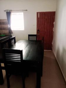 a dining room with a table and chairs and a door at Rooms with WiFi, Parking - 3BHK Villa in Kodaikānāl
