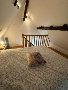 een bed met een kussen erop bij Manoir de la Vente de Rouville in Mesnil-Raoul