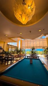 a pool table in a restaurant with a chandelier at Hotel Palacio Puerto Princesa in Puerto Princesa City