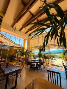 Un restaurante vacío con mesas, sillas y ventanas. en Hotel Palacio Puerto Princesa, en Puerto Princesa City