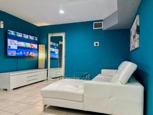Habitación con sofá blanco y pared azul en Hollywood Hideaway Spacious 2BR & Private Parking, en Hollywood