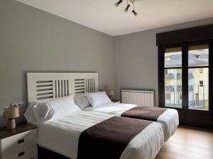 a bedroom with a large bed and a window at El Molino de Pochas in Bielsa