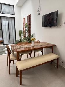 una sala da pranzo con tavolo in legno e panche di Mai House Jogja a Piyungan Altre 23 foto