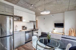 eine Küche und ein Wohnzimmer mit einem Glastisch in der Unterkunft Corporate Stays Le Shaughn 1 BR - Double Bed in Montreal