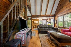 a living room with a couch and a tv at WiFi Pet Friendly Secluded Knotty By Nature in High Falls