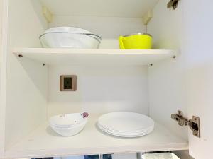 ein weißes Regal mit Tellern und Schüsseln darauf in der Unterkunft Apartment Kualalampur Near klcc Vortex suites in Kuala Lumpur + 31 Fotos