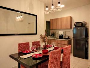 V Boho Home 3Bedroom 7-8Pax Eco Majestic Semenyih في Beranang: مطبخ مع طاولة مع كراسي حمراء وثلاجة