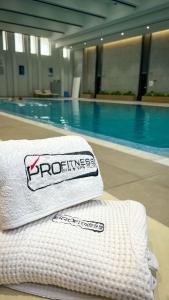 einen Haufen Handtücher neben einem Pool in der Unterkunft Tashkent city Boulevard resident 04 in Taschkent