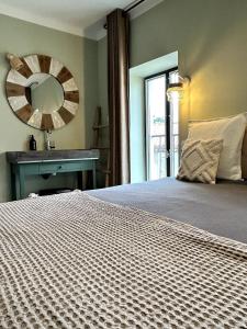 1 dormitorio con cama con espejo y lavamanos en Côté Nuit, en Capestang