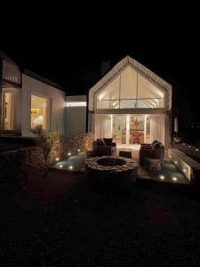 a living room with a glass house at night at Fish Eagle House on the Dam in Montagu
