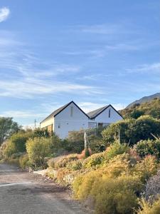 a white house on the side of a road at Fish Eagle House on the Dam in Montagu
