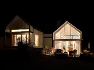 a house with a large glass extension at night at Fish Eagle House on the Dam in Montagu +45 photos