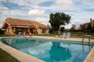 a swimming pool in front of a house at Casa Caliche in Madrid