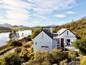a white house with a view of a river at Fish Eagle House on the Dam in Montagu
