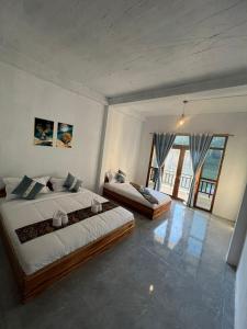a bedroom with two beds and a large window at Cam u view Guest House in Nongkhiaw