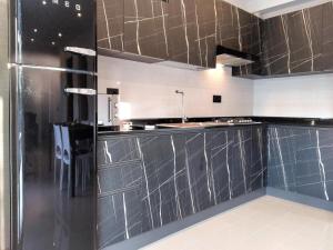 a kitchen with black and stainless steel counter tops at Modern villa close to the beach in Lignano Sabbiadoro