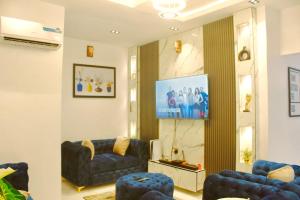 a living room with two couches and a flat screen tv at 2 Bedroom Apartment - Flixx & Flixx Apartments in Ibadan