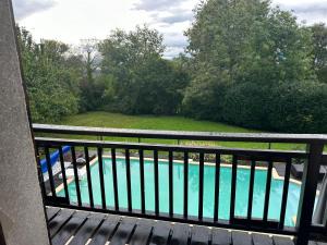 een balkon met uitzicht op een zwembad bij Chambres d'hôtes , Guest house in Chainaz-les-Frasses