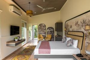 The Nest, Karjat في كارجات: غرفة نوم مع سرير وغرفة معيشة