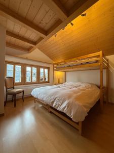 a bedroom with a bunk bed and a chair at Renovated traditional chalet in car-free Mürren in Mürren