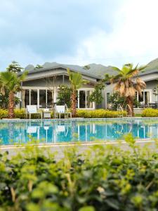 The Nest, Karjat في كارجات: منتجع مع حمام سباحة وأشجار النخيل