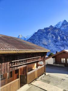 a house with a mountain in the background at Renovated traditional chalet in car-free Mürren in Mürren