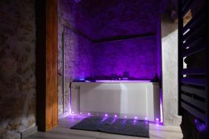 a white bath tub with purple lights in a room at Ca La Padrina in Torre del Español