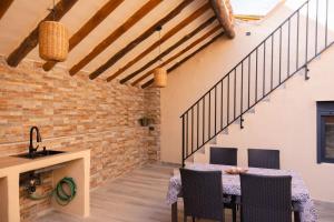 a kitchen and dining room with a table and chairs at Ca La Padrina in Torre del Español +4 photos
