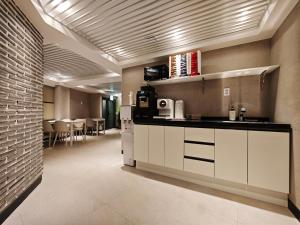 a kitchen with white cabinets and a dining room at Unit D Hostel in Seoul