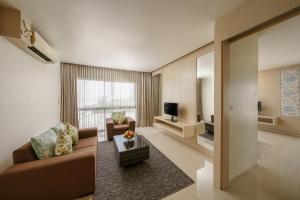 a living room with a couch and a television at Aspira Petchkasem in Ban Khlong Om Noi