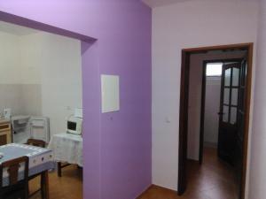 Zimmer mit einer lila Wand und einer Tür in der Unterkunft Damontanha in Ribeira Grande