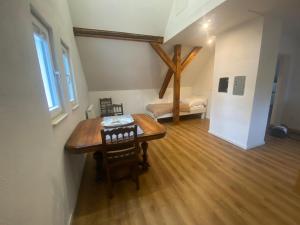 a dining room with a table and a bench in a room at Gästewohnung Augsburg - Spickel in Augsburg