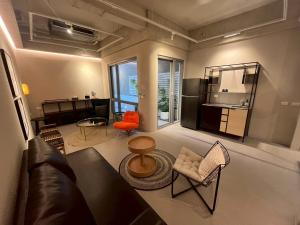 a living room with a couch and a table and chairs at Chuan Inn圈旅 站前館 in Tainan