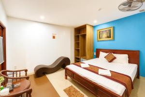 a bedroom with a bed with a blue wall at Hong Phuc Hotel 2 Da Nang in Danang