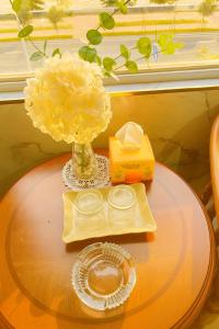 une table avec un vase de fleurs sur une table dans l'établissement Hong Phuc Hotel 2 Da Nang, à Đà Nẵng