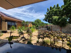 a garden with trees and a bench in front of a building at Cây Trôm Homestay 1 in Vĩnh Hy