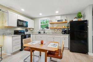 a kitchen with a table and a black refrigerator at Carriage House Retreat 1 in Milford