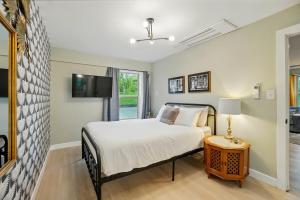 a bedroom with a bed and a tv on a wall at Carriage House Retreat 1 in Milford
