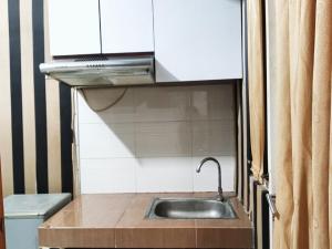 a kitchen with a sink and a microwave at Bram Rooms Green Lake View Ciputat in Pondokcabe Hilir +10 photos