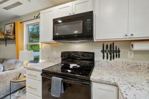 a kitchen with a stove and a microwave at Carriage House Retreat 1 in Milford +16 photos