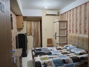 a small room with a bed and a kitchen at Bram Rooms Green Lake View Ciputat in Pondokcabe Hilir