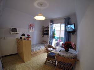 Habitación con cama, mesa y ventana en Apartamentos Montserrat, en Sitges