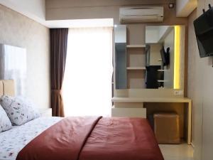 a bedroom with a bed and a mirror at Bram Rooms Green Lake View Ciputat in Pondokcabe Hilir