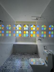 a bathroom with a sink and stained glass windows at Aryavarta A Boutique Abode in Nāi