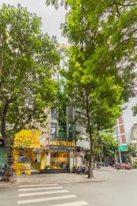 a building on a street with trees in front of it at A25 Hotel - 75 Lê Thị Hồng Gấm in Ho Chi Minh City