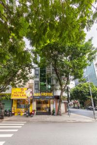 a building on a street with trees in front of it at A25 Hotel - 75 Lê Thị Hồng Gấm in Ho Chi Minh City