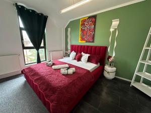 a bedroom with a large bed with a red headboard at Vitamine Central Apartment in Craiova