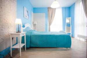 スヴェトロゴルスクにあるApartments Malina Park 2の青いベッドルーム(ベッド1台、テーブル付)