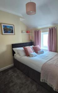 a bedroom with a large bed with pink curtains at Amaryllis Escapes in Brecon