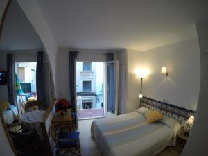 a bedroom with a bed and a large window at Apartamentos Montserrat in Sitges